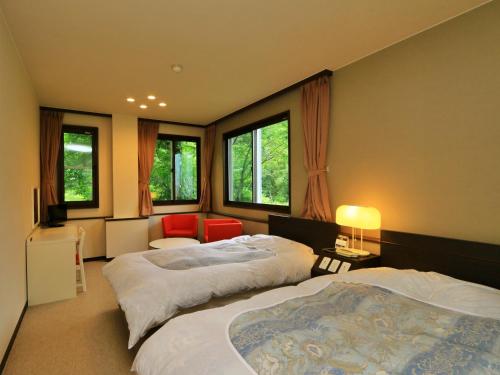 a bedroom with two beds and a room with windows at 苗場ビレッヂ in Yuzawa