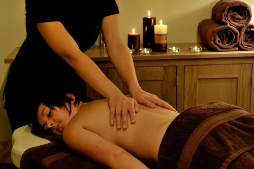 a woman getting a back massage from a pregnant woman at Eight Acres Hotel in Elgin
