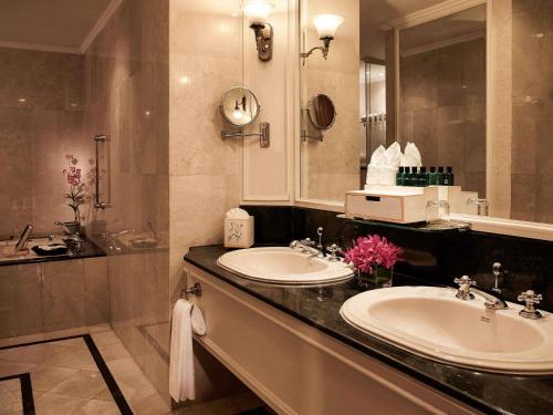 a bathroom with two sinks and a large mirror at Sofitel Angkor Phokeethra Golf & Spa Resort in Siem Reap
