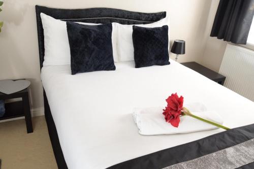 a white bed with a red flower on it at The Kyoto House - Four Spacious Cosy Bedrooms I Netflix & Large Rooms in Derby