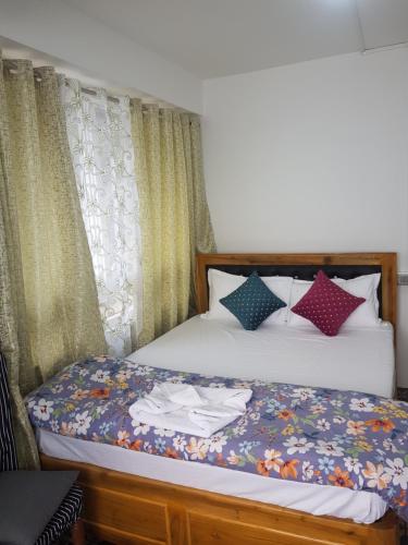 a bedroom with a bed with a dresser and curtains at Mannata Homesaty in Darjeeling