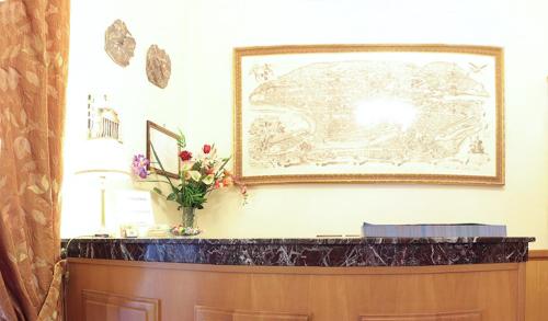 
a living room with a vase of flowers on the wall at Hotel Euro Quiris in Rome
