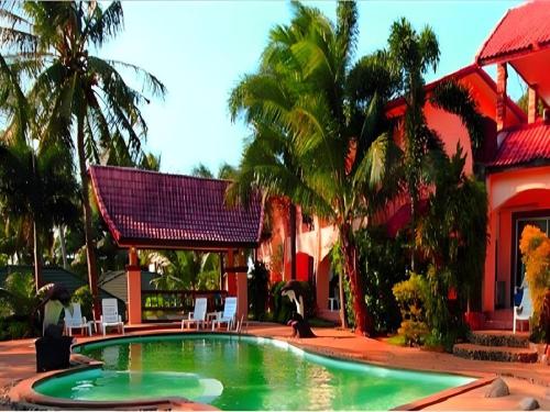 una piscina davanti a una casa con palme di Plaloma Cliff Resort a Ko Chang