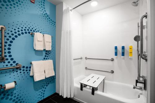 baño con bañera blanca y pared azul en Tru By Hilton Ocean City Bayside, Md, en Ocean City
