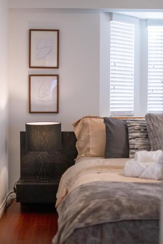 a bedroom with a bed and a table with a lamp at 3BR Near Commercial Dr 10 min to Downtown in Vancouver