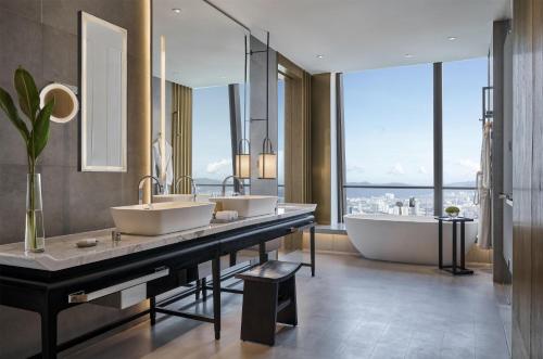 a bathroom with two sinks and a tub and a large window at Park Hyatt Kuala Lumpur in Kuala Lumpur