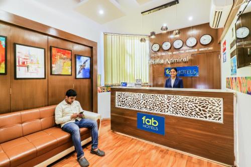 un hombre sentado en un sofá en una sala de espera en FabHotel Admiral - Nr Mumbai International Airport, en Bombay