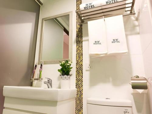 香港にあるMetro Winner Hotelの洗面台、鏡、トイレ付きのバスルーム