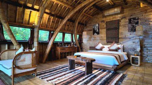 a bedroom in a log cabin with a bed and a table at Marilea Bamboo Villas Concept , Private pool, seaview, Adults only in Nusa Penida