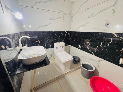 Un baño con lavabo e inodoro. en Ravrayhomestay, en Dholovira