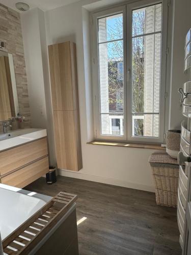 a kitchen with white walls and a large window at Charming house in Chantilly in Chantilly