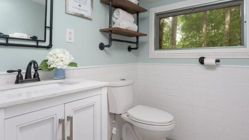 une salle de bain avec toilettes, lavabo et fenêtre dans l'établissement The Biddle House by AvantStay Breathtaking Views Walk to Lake, à Lake Harmony