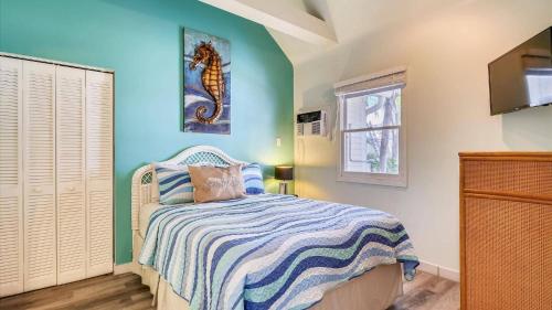 Un dormitorio con una cama con una pared azul. en Ibis by AvantStay Close to Duval Street w Shared Pool Month Long Stays Only, en Key West