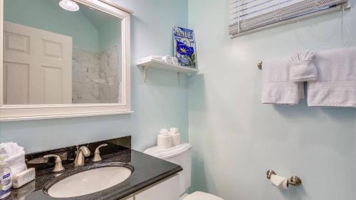 Un baño con lavabo, inodoro y espejo. en Ibis by AvantStay Close to Duval Street w Shared Pool Month Long Stays Only, en Key West