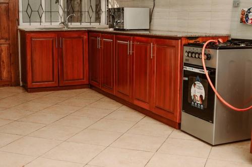 una cocina con armarios de madera y una estufa con manguera en Spine lobster, en Dar es Salaam