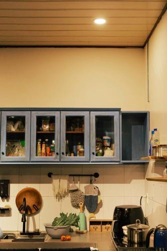 a kitchen with blue cabinets and a counter top at Như Là Home in Khu Chi Lăng