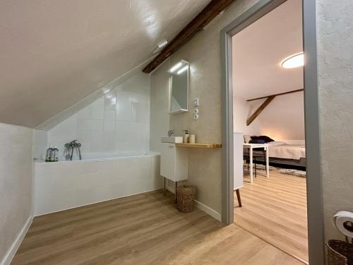 a bathroom with a bath tub and a bedroom at Mlýnská 53 in Kraslice