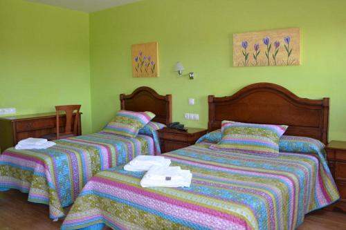 two beds in a bedroom with green walls at San Miguel de la Barreda in Siero