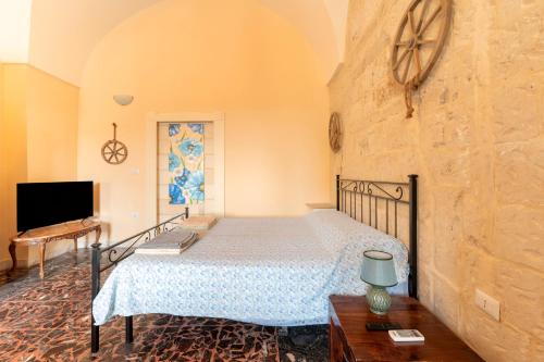 a bedroom with a bed and a tv in a room at Palazzo Costantini in San Donato di Lecce