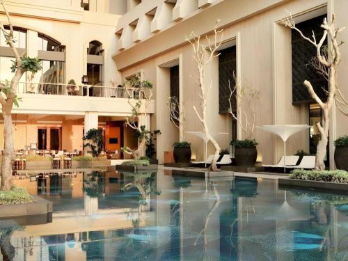 a hotel lobby with a pool in the middle at Hotel Tentrem Yogyakarta in Yogyakarta