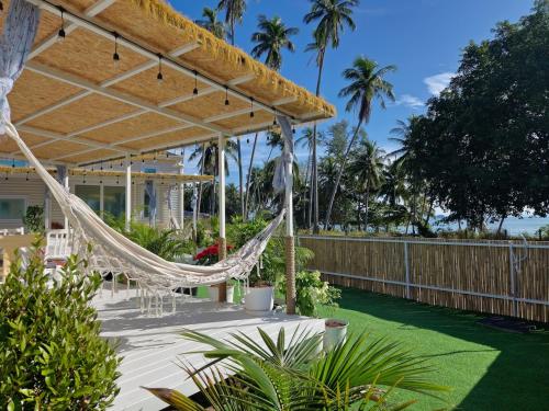 a hammock on the patio of a house at Samui Tiny House villa Glamping, Seaview Sleeps 8 in Amphoe Koh Samui