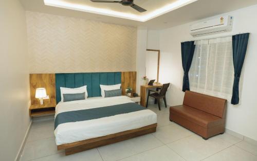 a bedroom with a bed and a chair and a window at Hotel Maya Elite in Bhopal