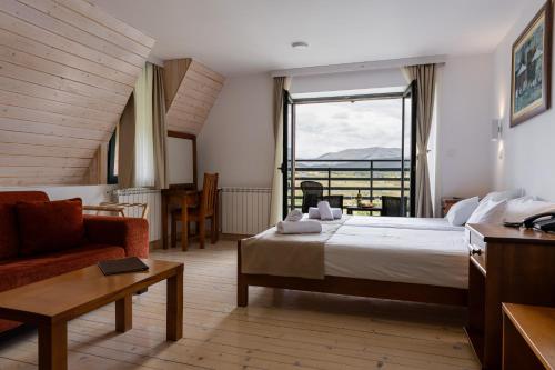 a hotel room with a bed and a large window at Hotel Polar Star in Žabljak