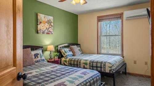 a bedroom with two beds and a window at Hickory Haven by AvantStay Hot Tub Game Room Theater Deck in Albrightsville
