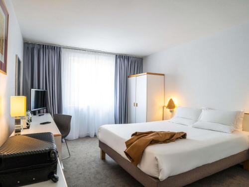 a hotel room with a large bed and a desk at Novotel Glasgow Centre in Glasgow