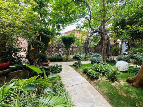 a garden with a walkway with plants and a fence at Dali Tanuki Fantasy Seaview Villa in Dali