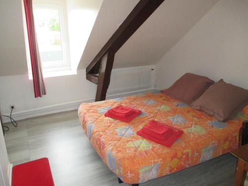 Saint-Aquilin-de-PacyにあるLe Grenier A Crepesのベッドルーム1室(赤い枕2つ付)