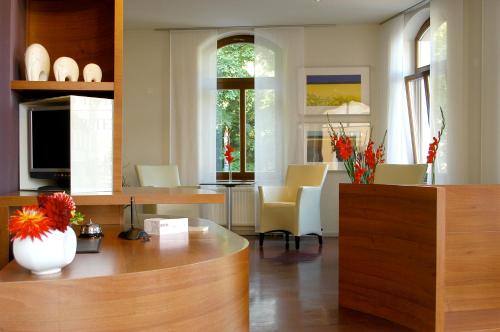 cocina y sala de estar con mesa y sillas en Hotel & Apartments Fürstenhof am Bauhaus, en Weimar