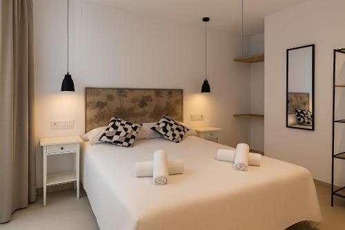 a bedroom with a large white bed with two pillows at El Jazmín del Patio in Nerja