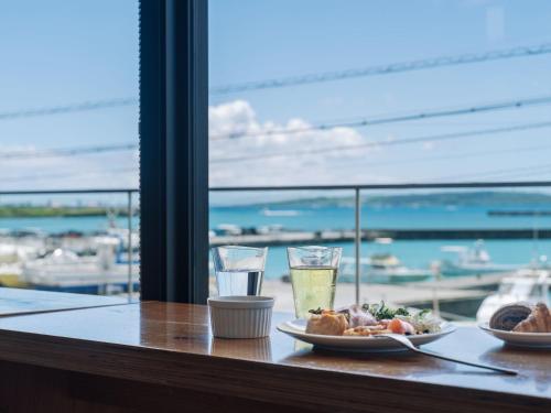 a table with two plates of food and glasses of water at Hotel Locus in Miyako Island