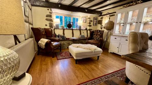 a bedroom with a bed and a desk and chairs at The Old Thatch - Hennock in Newton Abbot