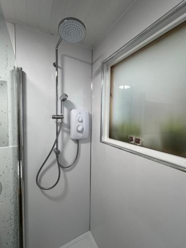 La salle de bains est pourvue d'une douche et d'une fenêtre. dans l'établissement Balnakyle, à Inverness