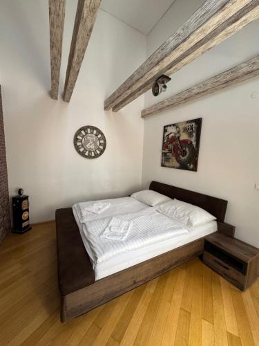 a bed in a room with a clock on the wall at Ultimate Group Getaway - Three of Everything! in Bratislava