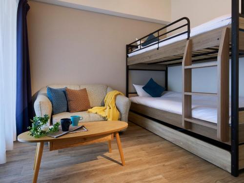 a living room with a bunk bed and a coffee table at Minn Umeda East in Osaka