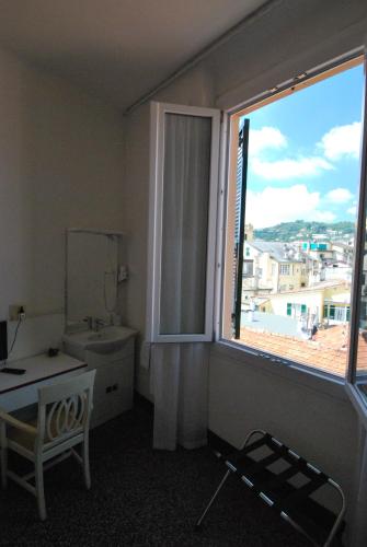 a bathroom with a window and a sink and a mirror at Albergo La Vela in Rapallo