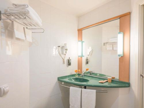 a bathroom with a green sink and a mirror at Hotel Ibis Firenze Prato Est in Campi Bisenzio