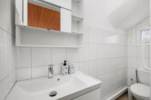 een witte badkamer met een wastafel en een toilet bij Shoreline Beach House in Larnaka