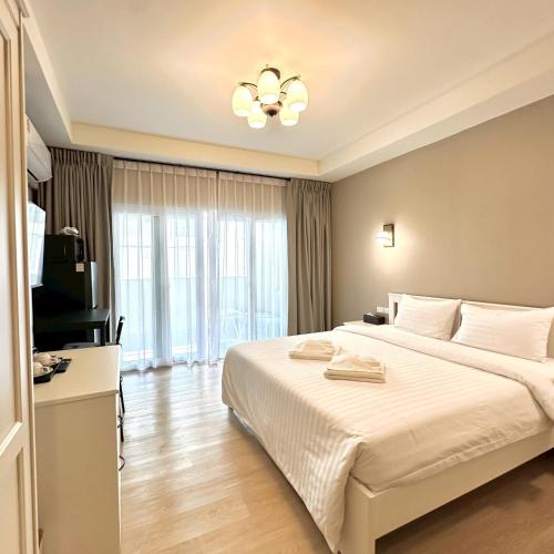 a bedroom with a large bed and a television at J STAR in Jomtien Beach