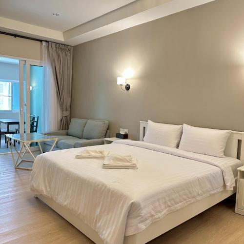 a bedroom with a large bed and a living room at J STAR in Jomtien Beach