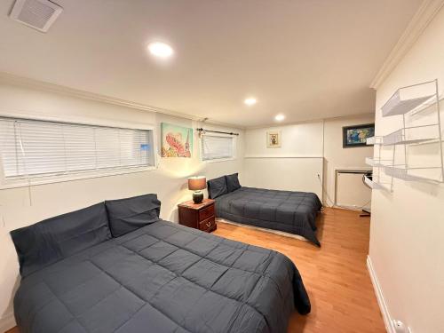 a bedroom with two beds and a couch in it at Downtown Central City Cozy Private 2 Bedroom Basement Suite - Independent Entry in Surrey