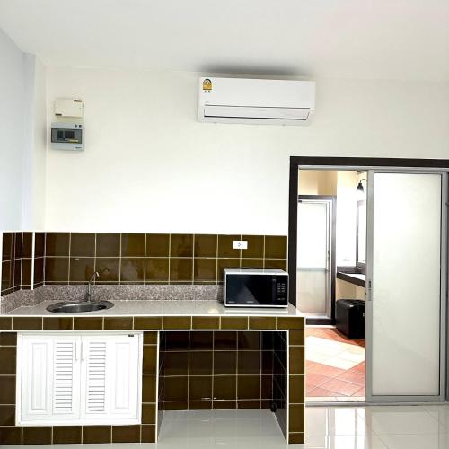 a kitchen with a sink and a microwave at J STAR in Jomtien Beach