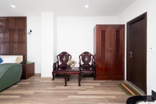 1 dormitorio con 2 sillas, mesa y puerta en Bình Triệu Hotel - Gò Vấp, en Ho Chi Minh