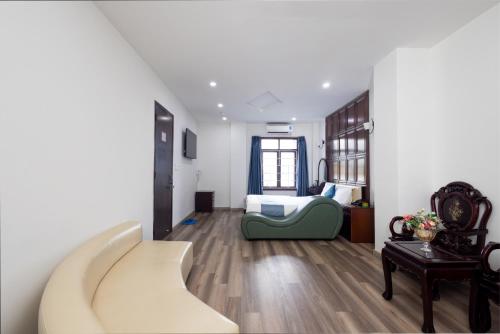 Un dormitorio con una cama y un sofá en una habitación. en Bình Triệu Hotel - Gò Vấp, en Ho Chi Minh