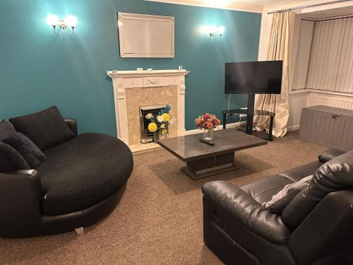 a living room with two couches and a fireplace at The Kyoto House - Four Spacious Cosy Bedrooms I Netflix & Large Rooms in Derby