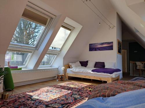 a bedroom with a bed and two windows at Ferienwohnung Rotbuche in Rastede