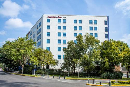 a white building with a sign on the side of it at Hampton by Hilton Guadalajara Expo in Guadalajara